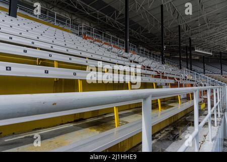 Große gelb-weiße Aufnahme der Tribüne mit Sicherheitsstange aus der Nähe. Stockfoto