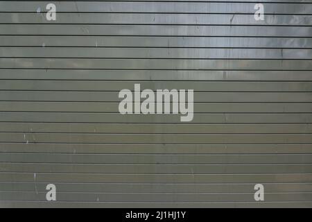 Glänzend graues Metall Garagentor Textur mit horizontalem Muster an der Wand. Stockfoto