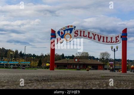 Eingang zum Themenpark mit Zugbanner mit Gebäuden im Hintergrund und blauem Himmel. Stockfoto