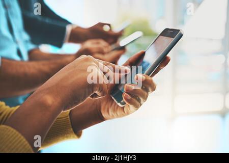 Wireless-Mitarbeiter. Eine kurze Aufnahme von nicht erkennbaren Geschäftsleuten, die ihre Handys im Büro benutzen. Stockfoto