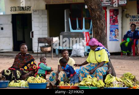 Tansanische Frauen verkaufen Bananen entlang der Straße in Mto Wa Mbu, Tansania. Stockfoto