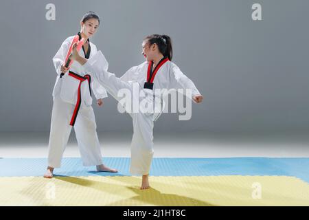 Der junge Trainer lehrt das Mädchen Taekwondo Stockfoto