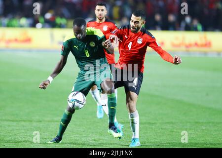 Kairo, Ägypten. 25. März 2022. Der senegalesische Cheikhou Kouyate (L) steht mit dem ägyptischen Amro Elsoulia (R) während der ersten Etappe des WM-Qualifikationsspiels 2022 zwischen Ägypten und Senegal am 25. März 2022 in Kairo, Ägypten, auf dem Spiel. Quelle: Ahmed Gomaa/Xinhua/Alamy Live News Stockfoto