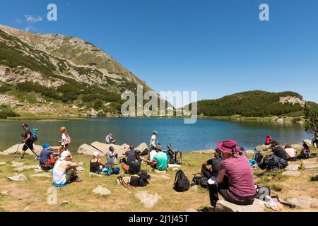 Bergwandern, Gruppe von Wanderern, die eine Pause am Muratovo See im Pirin Nationalpark und Naturschutzgebiet, Pirin Berg, Bulgarien, Balkan, Europa Stockfoto