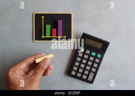 Diagramm der Verkaufszahlen auf dem Schwarzen Brett und dem Rechner. Berichtskonzept Geschäfts- und Vertriebsanalyse Stockfoto