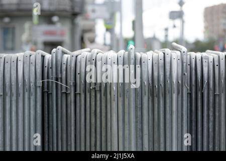 Temporärer Zaun. Metallteile von temporären Zäunen, tragbare Fußgängerbarriere montiert und stehen in einer Reihe Stockfoto