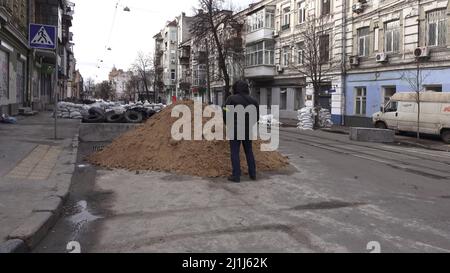 KIEW, UKRAINE 08. März. Ein Mitglied der Territorialen Verteidigungskräfte steht inmitten von von Sandsäcken geformten Barrikaden im historischen Viertel Podil im Distrikt Podilskyi unter Wache, während Russlands Invasion der Ukraine am 08. März 2022 in Kiew, Ukraine, fortgesetzt wird. Russland begann eine militärische Invasion der Ukraine, nachdem das russische parlament Verträge mit zwei abtrünnigen Regionen in der Ostukraine gebilligt hatte. Es ist der größte militärische Konflikt in Europa seit dem Zweiten Weltkrieg Stockfoto