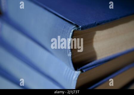 Blaue Bücher. Alte, zertrümmerte Buchdeckel mit dicken Bänden schließen sich an Stockfoto