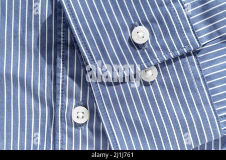 Manschetten. Ein zwei-Knopf-Bündchen auf einem blauen Hemd aus Bio-Baumwolle mit weißen Streifen. Details moderner Kleidung Stockfoto