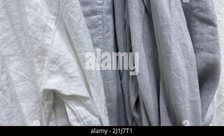 Weißer und grauer Leinenstoff. Zerknitterte Wäsche aus gewaschenen Leinen. Näh-Material Textur Stockfoto