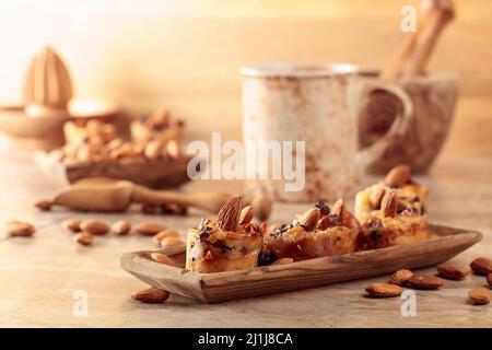 Kleine Kuchen mit Mandeln, Rosinen und Honig auf einem braunen Tisch. Stockfoto