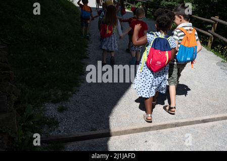 Ljubljana, Slowenien - 15. Juli 2021: Kinder mit Rucksäcken auf einer Schulreise. Kleinkinder halten sich die Hände. Gruppe von Kindern im Vorschulalter. Stockfoto