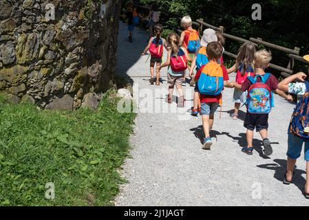 Ljubljana, Slowenien - 15. Juli 2021: Kinder mit Rucksäcken auf einer Schulreise. Kleinkinder halten sich die Hände. Gruppe von Kindern im Vorschulalter. Stockfoto