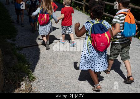 Ljubljana, Slowenien - 15. Juli 2021: Kinder mit Rucksäcken auf einer Schulreise. Kleinkinder halten sich die Hände. Gruppe von Kindern im Vorschulalter. Stockfoto