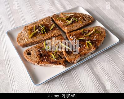 PA amb Oli geröstetes Brot mit Öl aus Mallorca, Spanien mit Rosmarinnadeln und Tomate Stockfoto