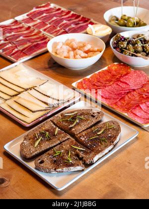 Gemischte spanische Tapas auf einem Tisch mit Pa amb oli Brot mit Öl, Manchego Käse und Chorizo Stockfoto