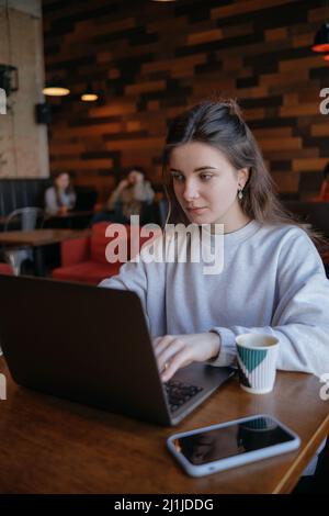 Freiberufliche Frau glücklich in einem Café aus der Ferne arbeiten Stockfoto