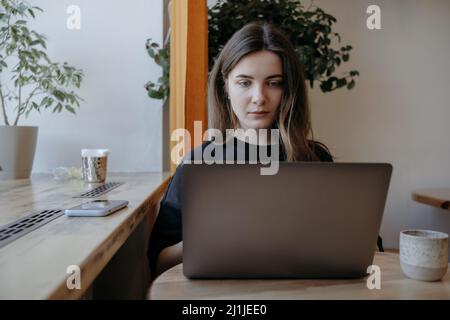 Freiberufliche Frau glücklich in einem Café aus der Ferne arbeiten Stockfoto