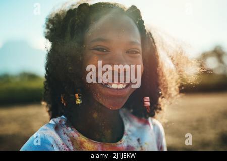 Sie wissen, dass Sie Spaß hatten, wenn Sie voller Farbe sind. Aufnahme eines Teenagers, das im Sommerlager Spaß mit buntem Pulver hat. Stockfoto