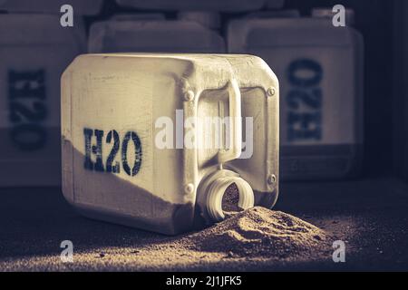 Mit Sand und Verschmutzung gefüllte Kanister mit unsauberem Wasser. Leere Plastikwasserbehälter in einem Wüstengebiet. Stockfoto