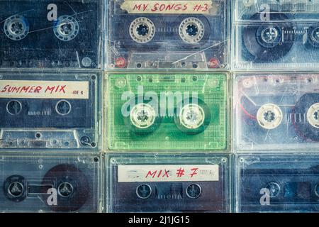 Alte, transparente Audiokassetten, die in einem Raster auf einem blauen Sofa angeordnet sind Stockfoto