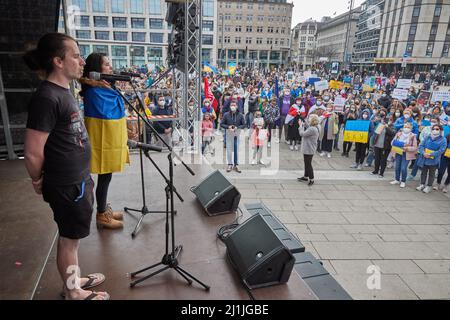 Hamburg, Deutschland. 26. März 2022. Alexei Voljuchik und Iryna das, Musiker, stehen während der Demonstration 'Frieden in der Ukraine - Sicherheit für Europa' auf der Bühne des Jungfernstieg und singen die ukrainische Nationalhymne. Quelle: Georg Wendt/dpa/Alamy Live News Stockfoto