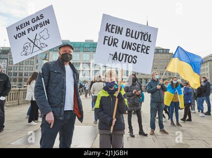 Hamburg, Deutschland. 26. März 2022. Oleg Friesen und sein Sohn Mats halten Transparente mit den Aufschriften "kein Gas aus Pupsin" und "kein Blutöl für unsere Autos" auf der Demonstration "Frieden in der Ukraine - Sicherheit für Europa" am Jungfernstieg. Quelle: Georg Wendt/dpa/Alamy Live News Stockfoto