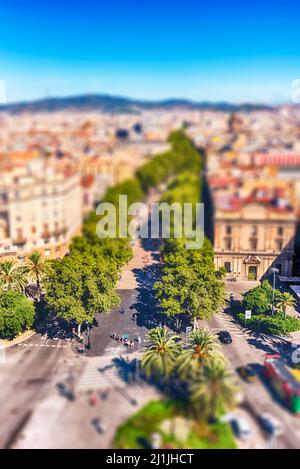 Malerische Luftaufnahme von La Rambla, von Bäumen gesäumte Fußgängerzone und beliebte Touristenattraktion in Barcelona, Katalonien, Spanien. Tilt-Shift-Effekt angewendet Stockfoto