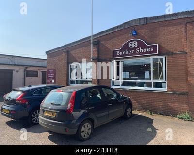 Barkers Schuhfabrik Shop in Earls Barton Northamptonshire UK Vordereingang Schilder Autos geparkt Auto vor Flaggenmast Geschichte Northampton Stockfoto