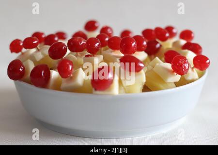 Ananas mit Käsekirsche. Eine leicht zu montierende, kochende Vorspeise. Aufgenommen auf weißem Hintergrund Stockfoto