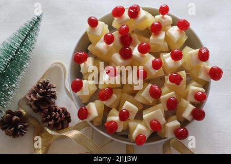 Ananas mit Käsekirsche. Eine leicht zu montierende, kochende Vorspeise. Aufgenommen auf weißem Hintergrund Stockfoto