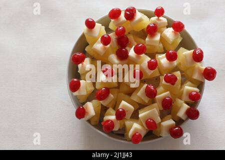 Ananas mit Käsekirsche. Eine leicht zu montierende, kochende Vorspeise. Aufgenommen auf weißem Hintergrund Stockfoto