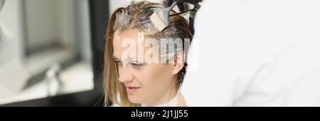 Frau färbt sich im Salon ihre Haare Stockfoto
