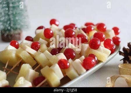 Ananas mit Käsekirsche. Eine leicht zu montierende, kochende Vorspeise. Aufgenommen auf weißem Hintergrund Stockfoto