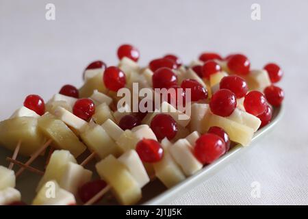 Ananas mit Käsekirsche. Eine leicht zu montierende, kochende Vorspeise. Aufgenommen auf weißem Hintergrund Stockfoto