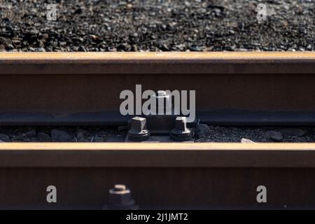 KPO Clip Rail Befestigungssystem und rostige Stahlbahn an einem Schmalspurbahnhof in Deutschland Stockfoto