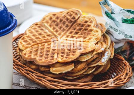 Waffel oder Waffeln in einem Korbkorb, Gericht aus gesäuertem Teig oder Teig, der zwischen zwei gemusterten Tellern gekocht wird Stockfoto