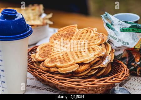 Waffel oder Waffeln in einem Korbkorb, Gericht aus gesäuertem Teig oder Teig, der zwischen zwei gemusterten Tellern gekocht wird Stockfoto