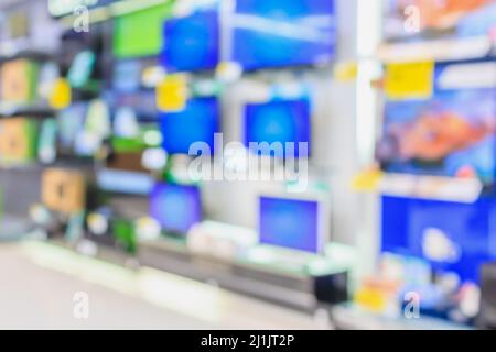 Eletronisches Kaufhaus mit verschwommenen Fernsehregalen im Hintergrund Stockfoto