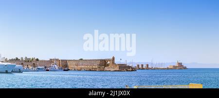 Panoramablick auf Mandraki Hafen und Yachthafen an der Stelle des Kolosses von Rhodos. Anlegestellen von Yachten und Schiffen. Alte Windmühlen am Pier. Eine Summe Stockfoto