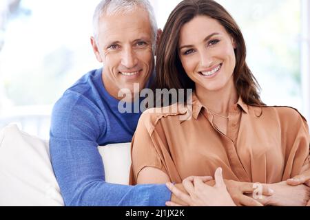 Unsere Liebe wird alles unterstützen. Porträt eines reifen Mannes, der hinter seiner jüngeren Frau steht. Stockfoto