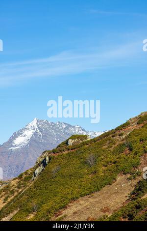 Schöne Landschaft in den Bergen mit Gipfeln gegen den blauen Himmel und mit Gras bedeckten Tälern Stockfoto