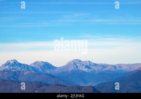 Schöne Landschaft in den Bergen mit Gipfeln gegen den blauen Himmel und mit Gras bedeckten Tälern Stockfoto