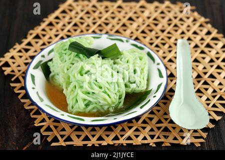 Putu Mayang oder Petulo, traditioneller indonesischer Snack aus Reismehl mit grüner Farbe, serviert mit Palmzucker-Sirup und Kokosmilch Stockfoto