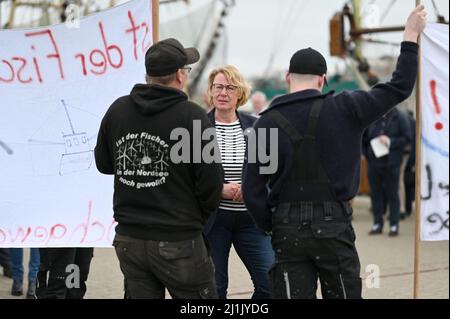 Greetsiel, Deutschland. 26. März 2022. Die niedersächsische Landwirtschaftsministerin Barbara Otte-Kinast (CDU, M) spricht mit demonstrierenden Fischern im Hafen. In einem Forschungsprojekt sollen Möglichkeiten für eine größere regionale Wertschöpfung in der Krabbenfischerei in Norddeutschland untersucht werden. Quelle: Lars Klemmer/dpa/Alamy Live News Stockfoto