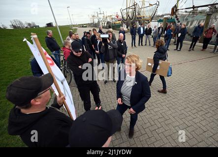 Greetsiel, Deutschland. 26. März 2022. Die niedersächsische Landwirtschaftsministerin Barbara Otte-Kinast (CDU, M) spricht mit demonstrierenden Fischern im Hafen. In einem Forschungsprojekt sollen Möglichkeiten für eine größere regionale Wertschöpfung in der Krabbenfischerei in Norddeutschland untersucht werden. Quelle: Lars Klemmer/dpa/Alamy Live News Stockfoto