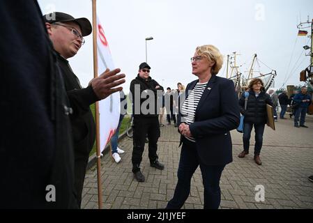 Greetsiel, Deutschland. 26. März 2022. Die niedersächsische Landwirtschaftsministerin Barbara Otte-Kinast (CDU, M) spricht mit demonstrierenden Fischern im Hafen. In einem Forschungsprojekt sollen Möglichkeiten für eine größere regionale Wertschöpfung in der Krabbenfischerei in Norddeutschland untersucht werden. Quelle: Lars Klemmer/dpa/Alamy Live News Stockfoto