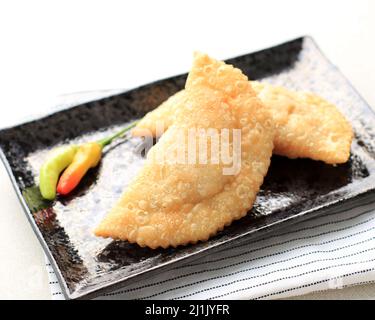 Kue Pastel oder Jalangkote, beliebtes Gericht aus Südostasien als Curry-Puff. Dieser Snack mit Reisnudeln, Karotten, Kartoffeln gefüllt und mit Gree serviert Stockfoto