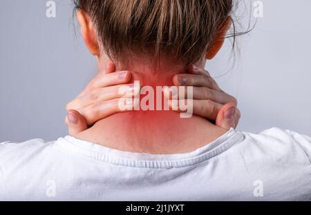 Nackenschmerzen aus der Nähe. Schmerzen im Nacken. Person, die an Verletzungen, Belastungen leidet. Stockfoto