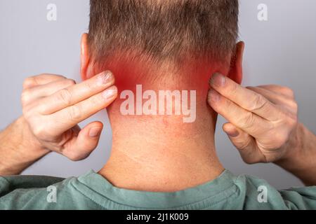 Nackenschmerzen aus der Nähe. Schmerzen im Nacken. Mann, der an Verletzungen, Belastungen leidet. Stockfoto